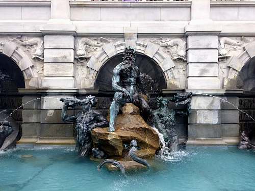 water grey and brown statue in garden pond the court of neptune fountain