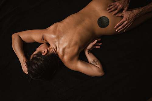 human topless woman lying on black textile back