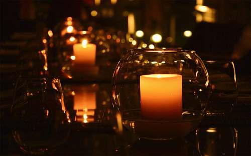 lighting lit pillar candle in clear glass holder fire