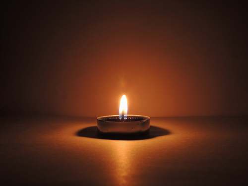 fire round ceramic bowl with lighted candle brown