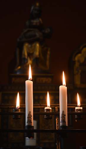 fire white pillar candles on black metal candle holders close-up photography flame