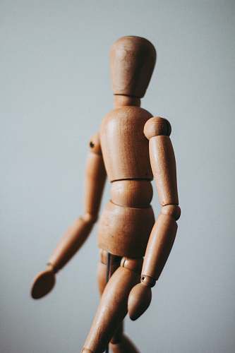  colse-up photo of brown wooden doll 