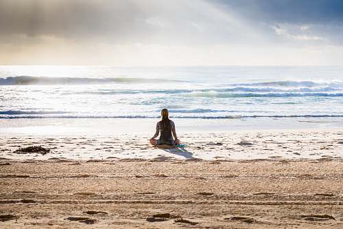  woman sitting on seashore 