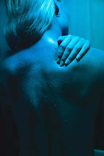 back woman covering her face with her hands blue
