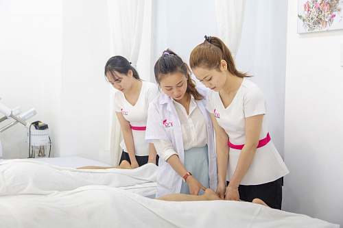 person one woman assisting another woman in massaging massage