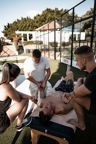 person photography of man in white shirt doing massage of another man who lying on massage bed massage