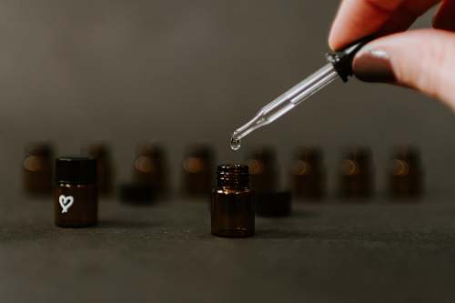 person selective focus photography of brown tinted glass bottle office