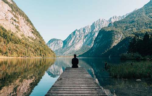 travel man sitting on gray dock meditation