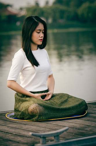 people woman meditating on wooden dock during daytime female