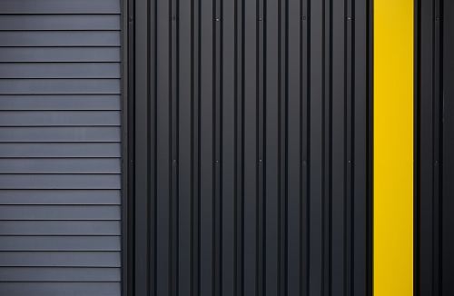 a yellow door on a black house