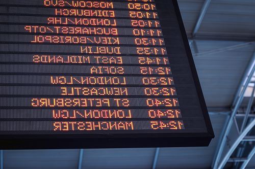 A low-angle shot of a departure board at an airport