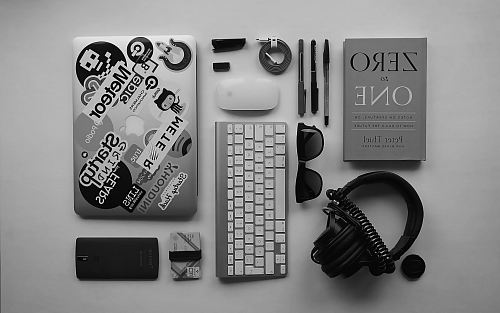 black corded headphones, silver MacBook, Apple wireless keyboard, and Apple Magic Mouse