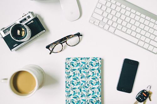 black frame eyeglasses beside black and gray SLR camera