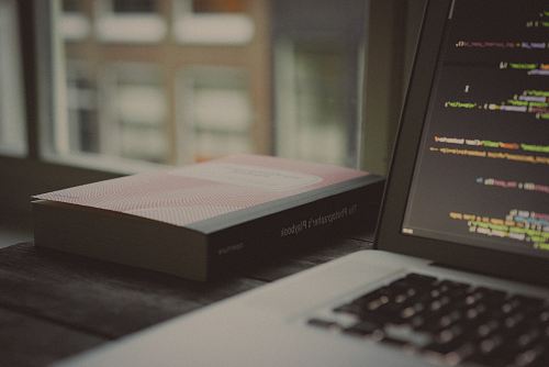book beside laptop computer