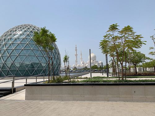 concrete pavements near round glass-curtain building during daytime