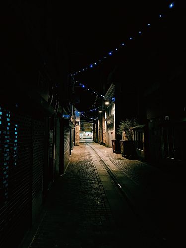 empty alley between houses and stores at night