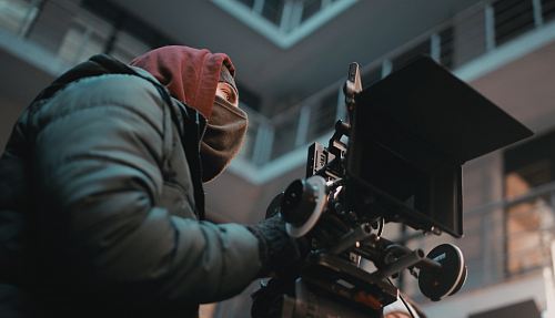 focus photography of man in black jacket with camera
