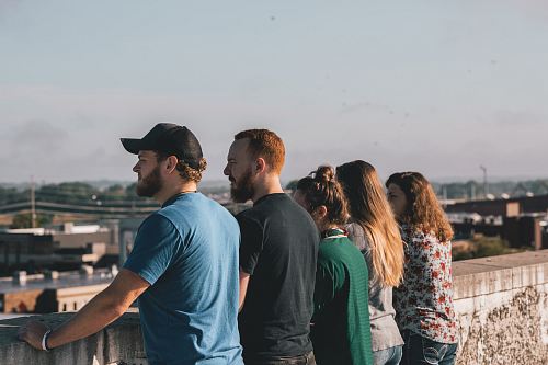 four people leaning on concrete rails