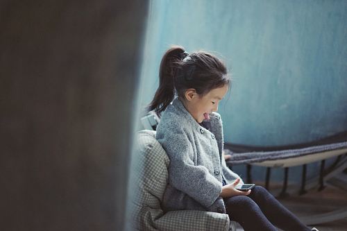 girl sticking her tongue out while using mobile phone