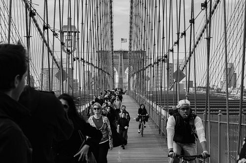 grayscale photo of people on bridge