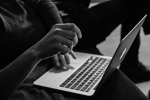 grayscale photo of person using MacBook