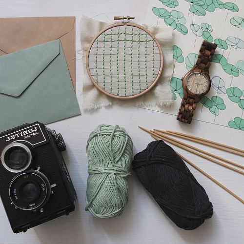 green and black yarns with round brown watch and black Lubitel camera