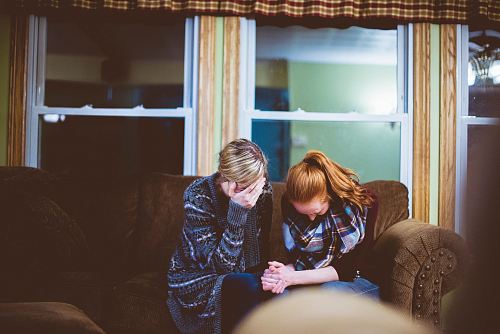 man and woman sitting on sofa in a room