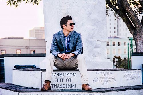 man in blue suit jacket sitting near tree