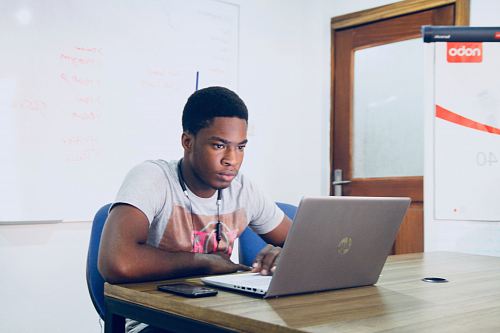 man in grey shirt using grey laptop computer