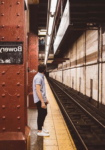 man standing beside subway platform