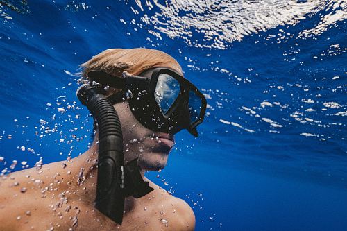 man wearing black goggles under water