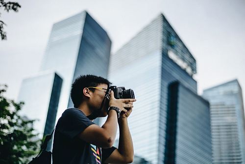 man wearing black t-shirt holding DSLR camera
