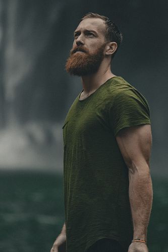 man wearing green crew-neck t-shirt looking upwards