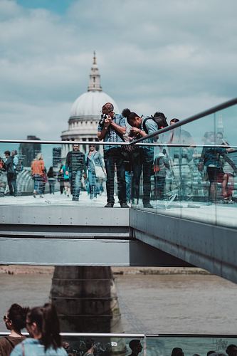 people standing over railings taking a photo