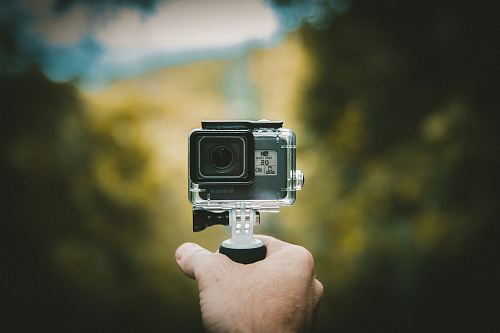 person holding action camera
