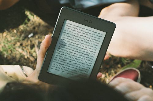 person holding black Amazon Kindle e-book reader