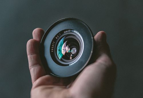person holding black camera lens