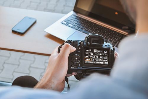 person holding black DSLR camera