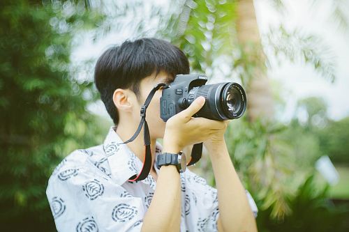person holding black DSLR camera