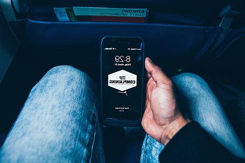 person holding phone displaying stop complaining text screengrab