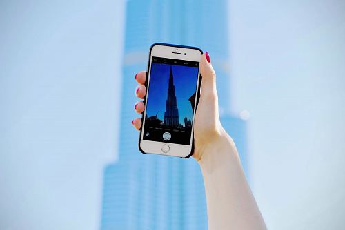 person holding silver iPhone 6 and black case