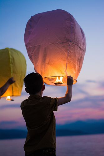 person holding yellow flammable balloon