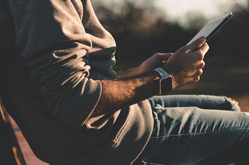 person sitting on chair using tablet