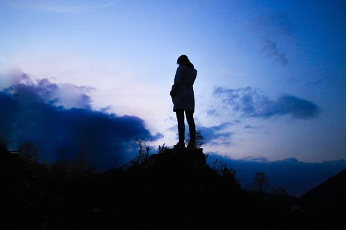 person standing on boulder during twilight