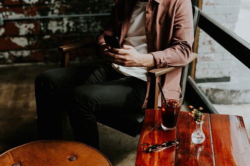 person using smartphone sitting on chair