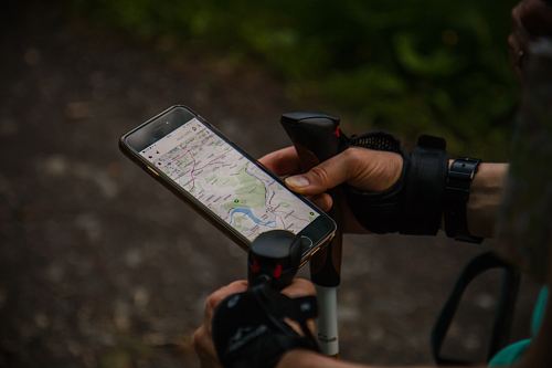 person using smartphone with nordic walking sticks