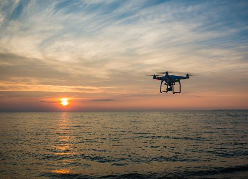 quadcopter flying over body of water
