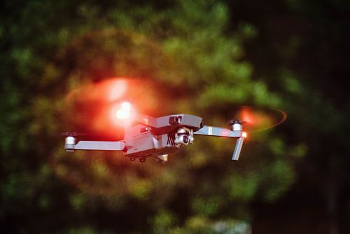 selective focus photography of drone flying on mid-air during nighttime