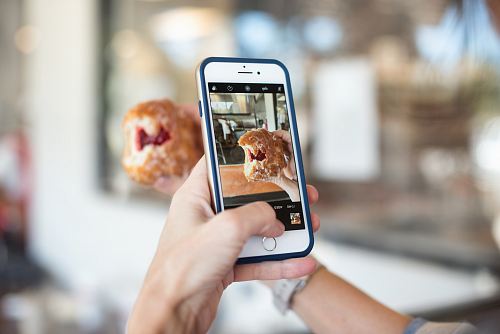 selective focus photography of person taking picture of brown food