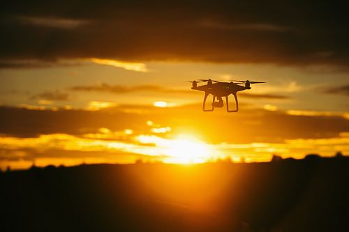 silhouette camera drone flying midair